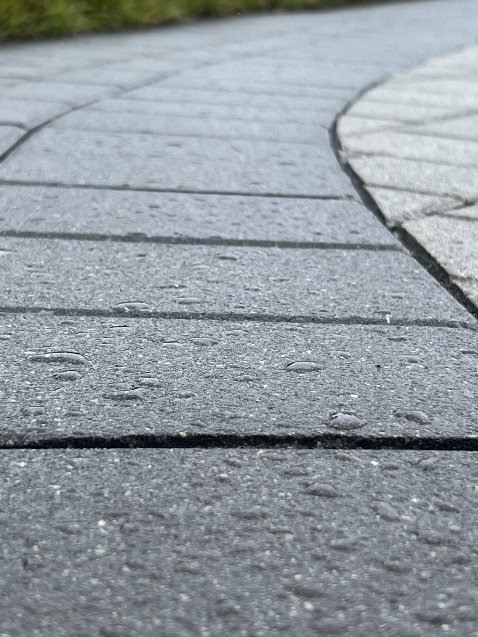 Water beading into droplets on a sealed paver surface