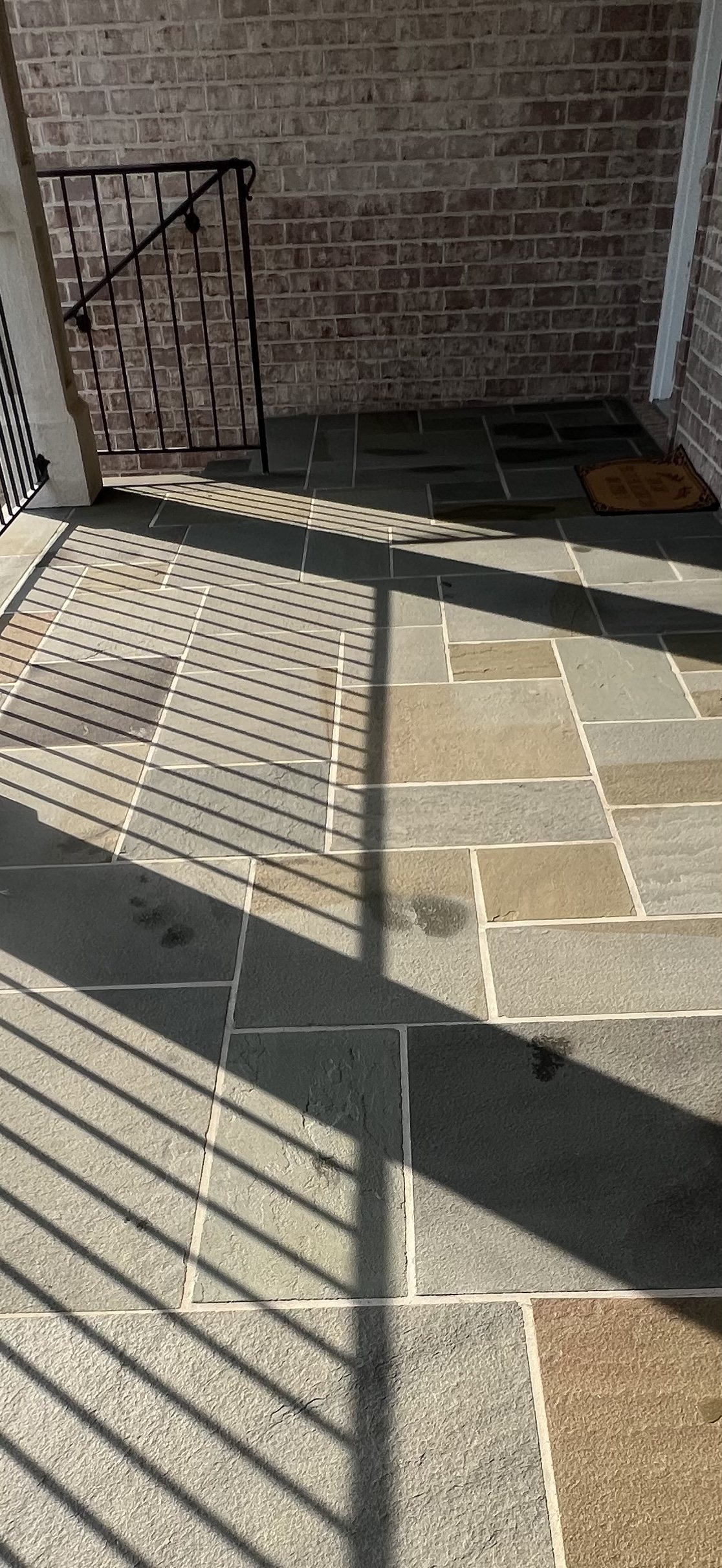 The same bluestone patio after the failed sealer was stripped off, with the natural stone color clear again