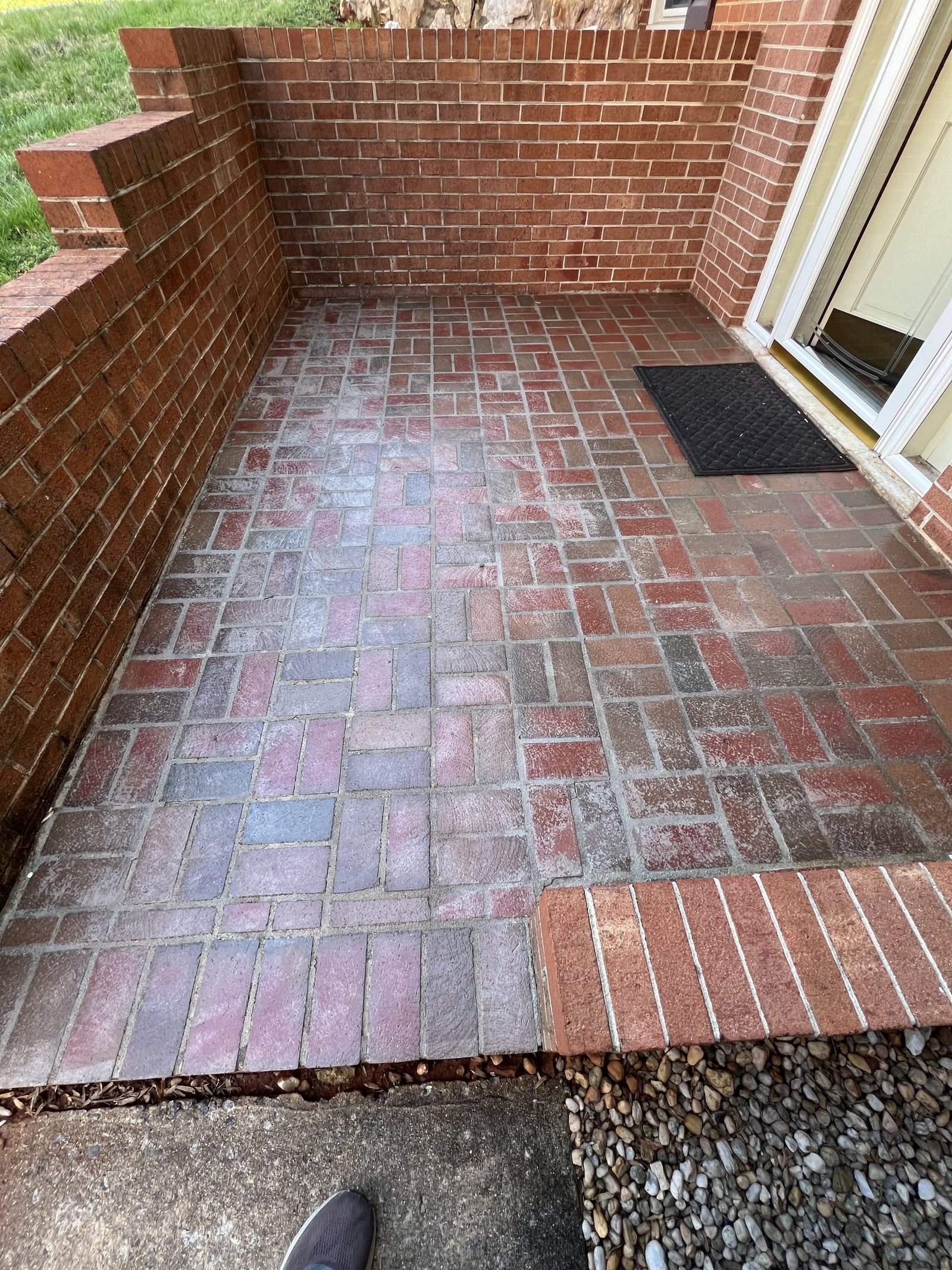 Milky white clouding across a sealed clay brick paver porch