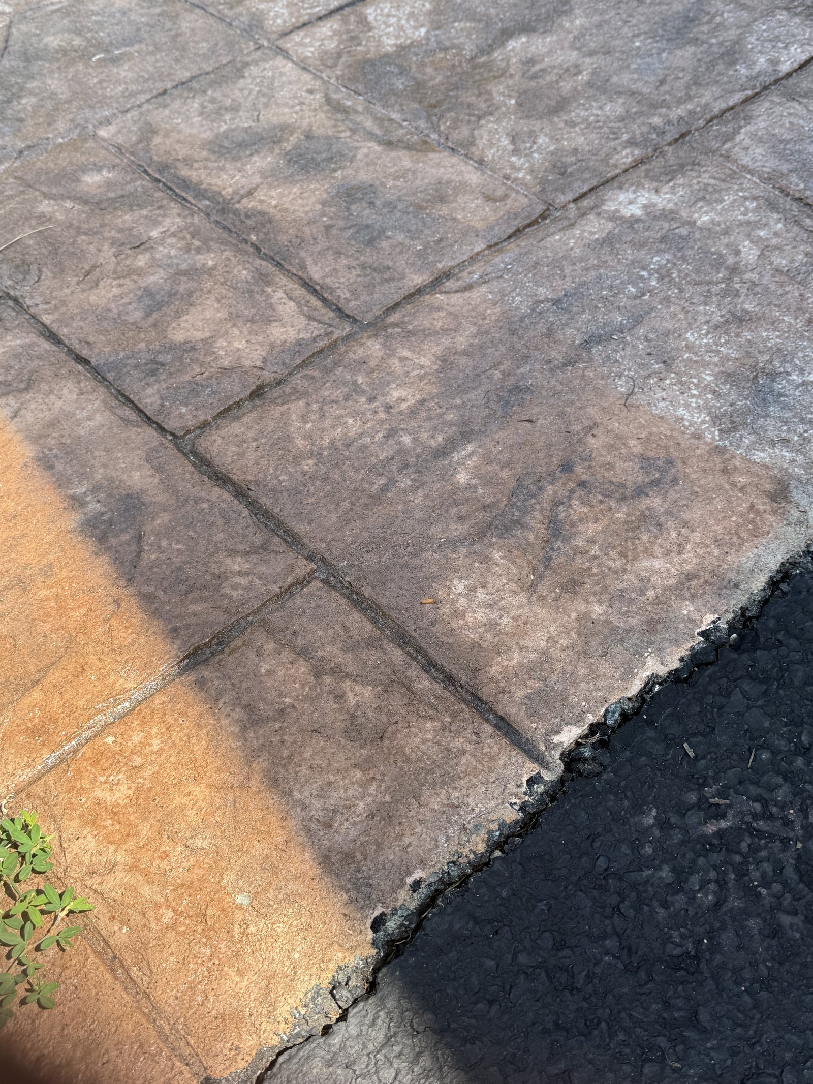Test spot on clouded stamped concrete where the failed surface coat was washed off, showing the original color underneath
