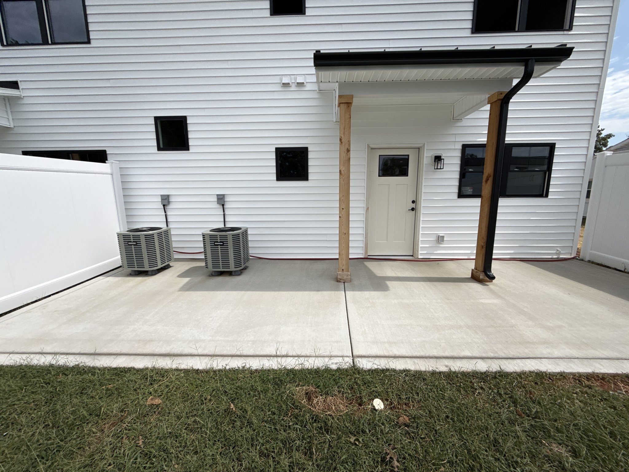 Rear patio concrete restored to an even gray after new construction cleaning in Lynchburg, VA