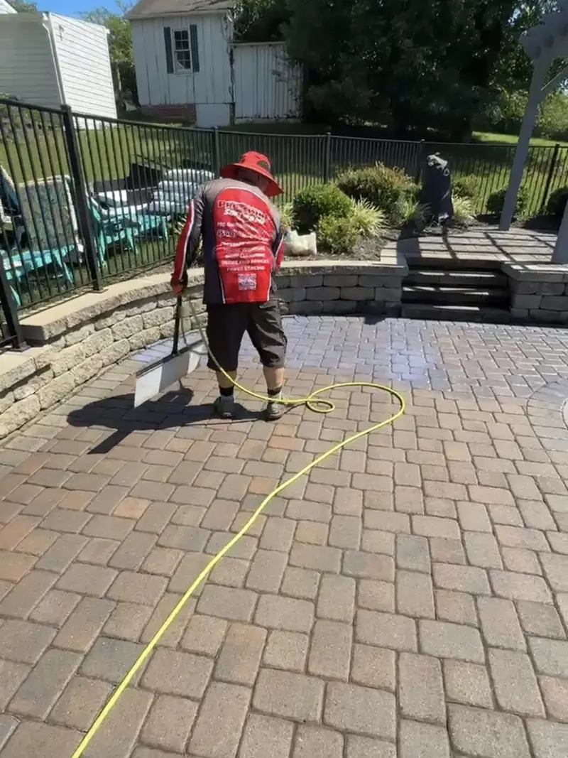 Spreading paver sealer across a pool patio with an applicator in Rocky Mount, VA