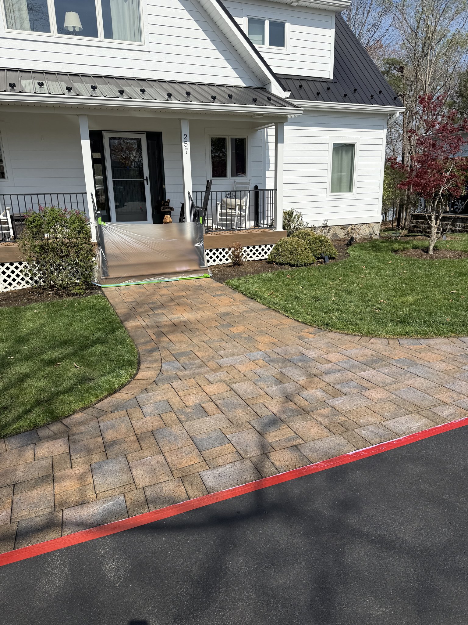 Front paver walkway with porch masked off during sealer application