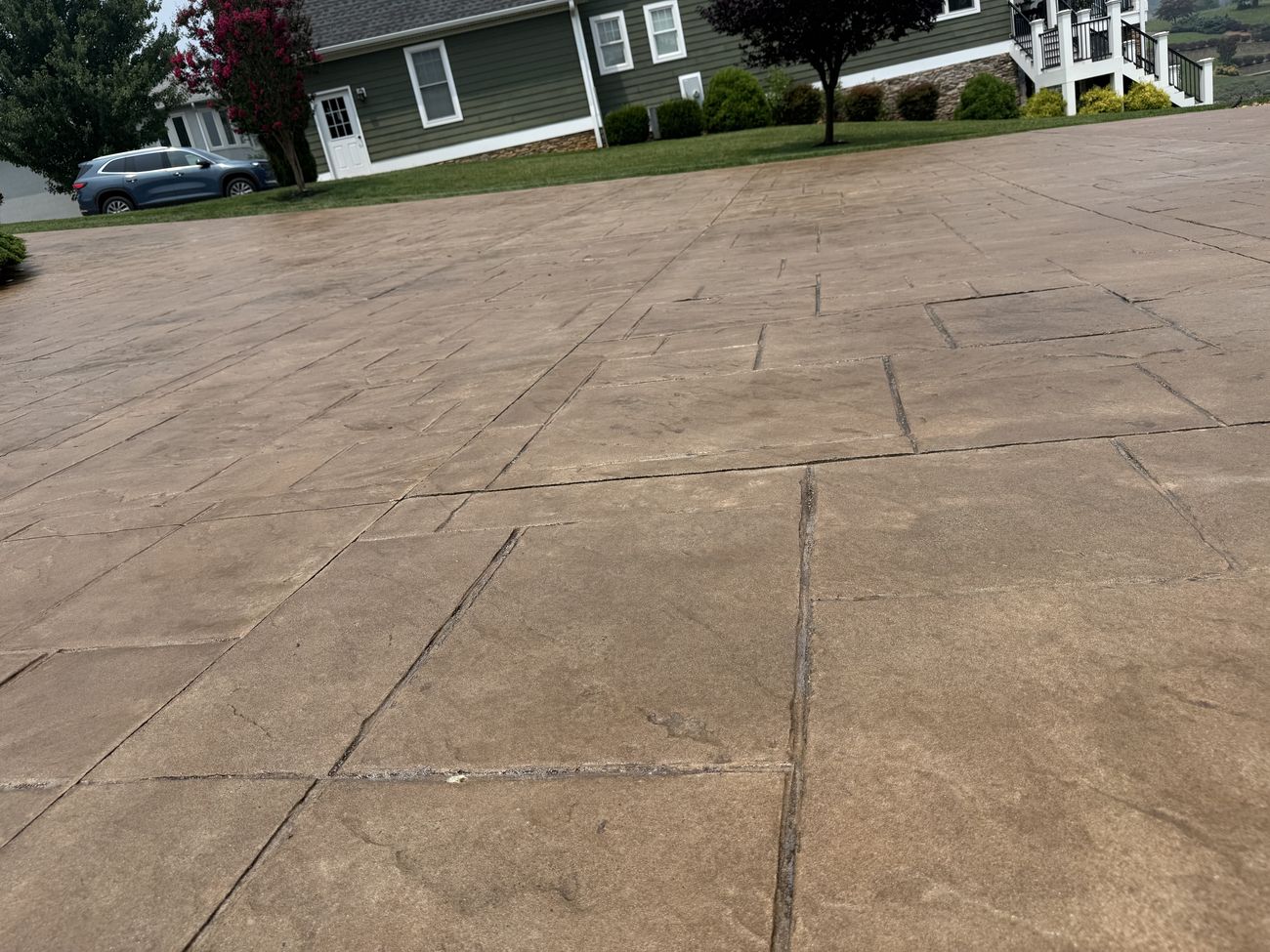 Wide view of sealed stamped concrete driveway after restoration