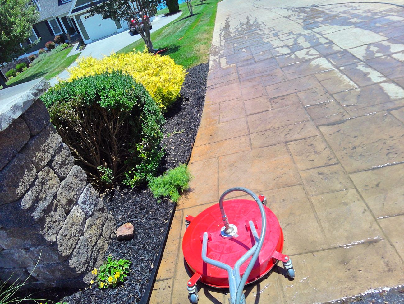 Professional surface cleaner deep cleaning stamped concrete along landscaping in Moneta, VA